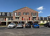 Thumbnail 10 of 33 - Georgetown Apartments of St. Louis brick building with second-floor balconies and parking lot.
