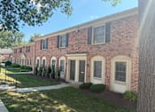 Thumbnail 26 of 26 - A row of red brick houses with white trim and black shutters.