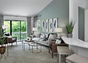 Thumbnail 1 of 33 - Spacious living room at River Oaks at Rochester Hills Apartments with sofa, accent wall, and sliding glass door to balcony.
