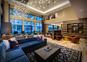 Thumbnail 24 of 24 - A modern living room with a large blue couch and a coffee table.