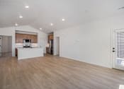 Thumbnail 19 of 23 - A kitchen with wooden floors and white walls at Bloom Rental Living apartments in Fort Collins, CO.
