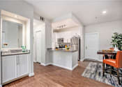 Thumbnail 4 of 45 - A kitchen with white cabinets and a wooden floor.