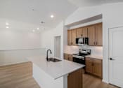 Thumbnail 18 of 23 - A kitchen with a white counter top and wooden cabinets at Bloom Rental Living apartments in Fort Collins, CO.