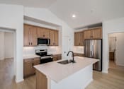 Thumbnail 17 of 23 - A kitchen with a white counter top and wooden cabinets at Bloom Rental Living apartments in Fort Collins, CO at Bloom Rental Living apartments in Fort Collins, CO.