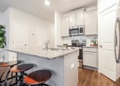 Thumbnail 55 of 60 - a kitchen with white cabinets and a granite counter top