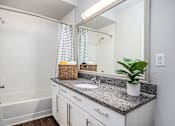 Thumbnail 6 of 45 - A bathroom with a white tub, sink, and a mirror.