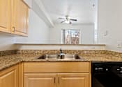 Thumbnail 8 of 19 - A kitchen with wooden cabinets and granite countertops.