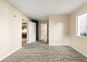 Thumbnail 21 of 36 - A room with a carpeted floor and a window on the right side.