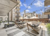 Thumbnail 23 of 29 - a rooftop patio with lounge chairs and umbrellas