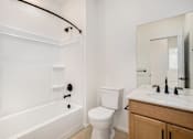 Thumbnail 20 of 23 - A white bathroom with a toilet, sink, and bathtub at Bloom Rental Living apartments in Fort Collins, CO.