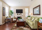 Thumbnail 8 of 29 - A living room with a couch, chair, and a television.