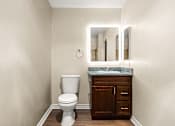 Thumbnail 23 of 36 - A white toilet sits in a bathroom next to a wooden cabinet.