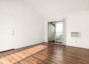 Thumbnail 14 of 33 - A room with a white door and a window with a view of trees.