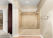 Thumbnail 22 of 36 - A bathroom with a walk-in shower and a doorway leading to another room.