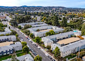 Thumbnail 10 of 55 - A large building complex with a parking lot in front of it at Hillsdale Garden Apartments, San Mateo, CA