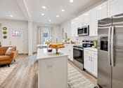 Thumbnail 4 of 37 - A modern kitchen with stainless steel appliances and white cabinetry
