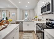 Thumbnail 3 of 37 - A modern kitchen with white cabinets and stainless steel appliances.