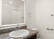 Thumbnail 24 of 33 - A bathroom with a sink, mirror, and towel rack.