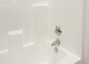 Thumbnail 26 of 33 - A white bathtub with a shower head and faucet.