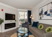 Thumbnail 3 of 24 - a living room with a fireplace and a couch and a glass coffee table