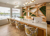 Thumbnail 16 of 29 - A kitchen with a white counter and yellow chairs.