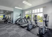 Thumbnail 20 of 29 - A gym with treadmills, elliptical machines, and a stationary bike.