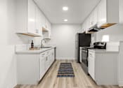 Thumbnail 9 of 36 - A modern kitchen with white cabinets and stainless steel appliances.