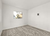 Thumbnail 30 of 36 - A room with a carpeted floor and a window.