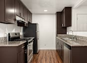 Thumbnail 15 of 33 - A kitchen with brown cabinets and a black refrigerator.