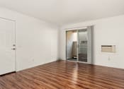 Thumbnail 19 of 33 - A room with a wooden floor and a white door.