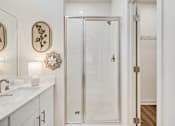 Thumbnail 24 of 37 - A white bathroom with a glass shower door.