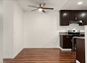 Thumbnail 18 of 33 - A kitchen with brown cabinets and a ceiling fan.