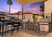 Thumbnail 7 of 33 - A patio with a table and chairs and a grill.