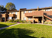 Thumbnail 34 of 36 - A large apartment complex with a green lawn in front.