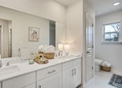 Thumbnail 29 of 37 - A bathroom with two sinks and a large mirror.