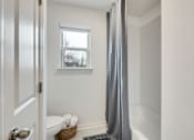 Thumbnail 30 of 37 - A bathroom with a white toilet and a grey shower curtain
