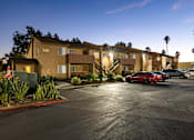 Thumbnail 35 of 36 - A parking lot with cars and apartment buildings in the background.