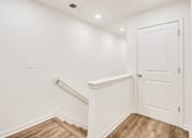 Thumbnail 19 of 37 - A white door is on the right side of a hallway.