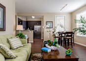 Thumbnail 7 of 29 - A living room with a green couch and a wooden coffee table.