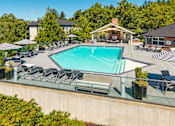 Thumbnail 1 of 29 - A large swimming pool surrounded by lounge chairs and umbrellas.