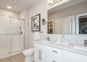 Thumbnail 8 of 24 - a bathroom with a shower and a sink and a mirror