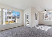 Thumbnail 21 of 36 - A spacious room with a grey carpet and a ceiling fan.