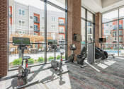 Thumbnail 18 of 24 - a workout room with weights and cardio equipment in a building with large windows