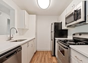 Thumbnail 13 of 52 - A kitchen with black appliances and white cabinets.