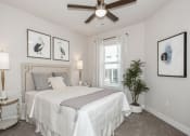 Thumbnail 6 of 24 - a bedroom with a bed and a ceiling fan