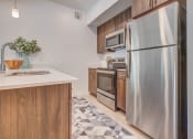 Thumbnail 2 of 34 - a kitchen with wooden cabinets and stainless steel appliances