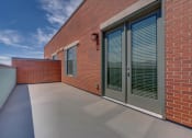 Thumbnail 26 of 34 - a large patio with a brick wall on the side of a building