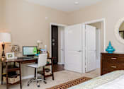 Thumbnail 12 of 29 - A room with a desk, chair, and bed.