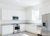 Thumbnail 17 of 18 - A modern kitchen with white cabinets and stainless steel appliances.at The Yarra, Tennessee