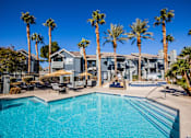Thumbnail 1 of 44 - A swimming pool surrounded by palm trees and lounge chairs.